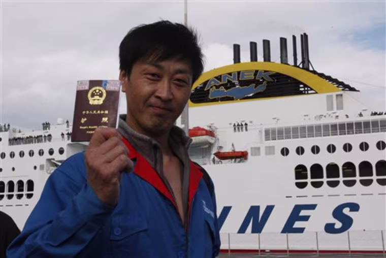 A Chinese evacuee shows his passport upon his arrival at the port of Iraklio city, on the Greek island of Crete, Thursday, Feb. 24, 2011. Two Greek ferries carried some 4,500 Chinese and other nationalities arrived from violence-torn Libya . (AP Photo/Thanassis Stavrakis)
